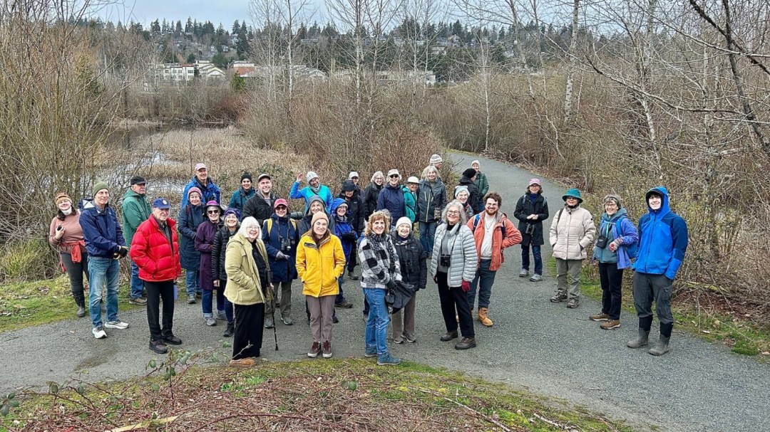 Photo features a group of people standing together outside during a birding outing.