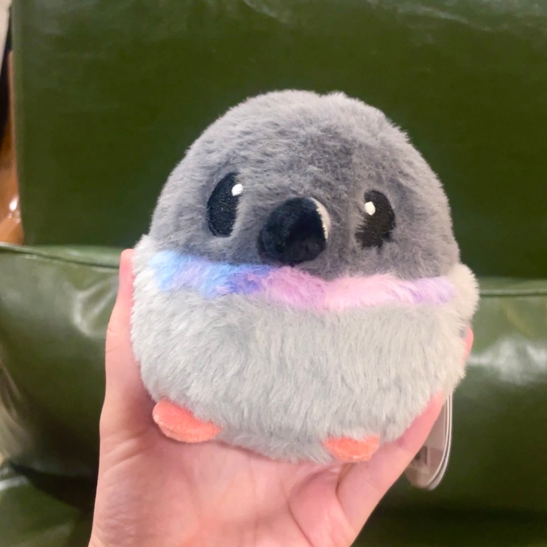 Photo features a round, grey, pigeon plush toy.